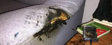 El sillón parcialmente quemado al estallar el móvil que estaba cargando en la mesita de al lado El sillón parcialmente quemado al estallar el móvil que estaba cargando en la mesita de al lado