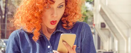 Mujer sorprendida al mirar el móvil Mujer sorprendida al mirar el móvil