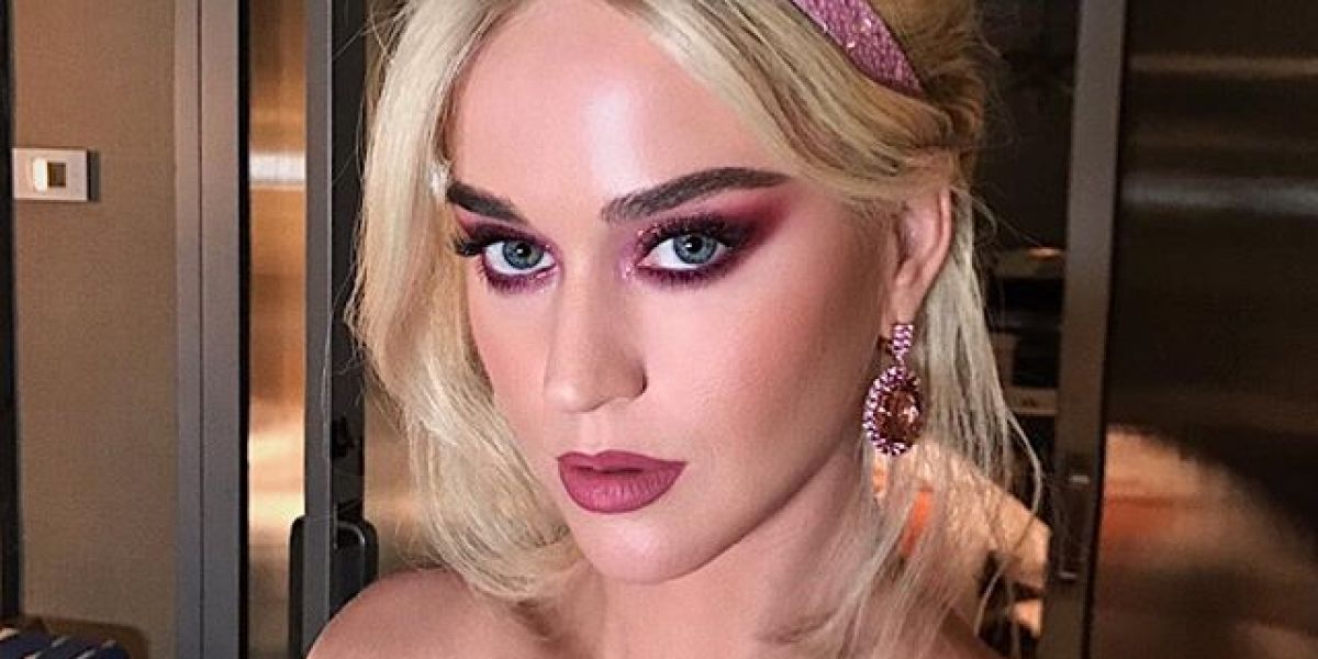 Katy Perry con la melena rubia y un mono de color rosa pastel