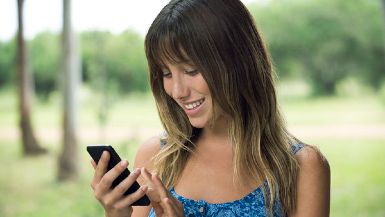 Una chica mirando su teléfono móvil Una chica mirando su teléfono móvil