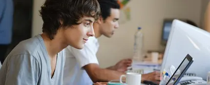 Chico mirando el portátil en una cafetería Chico mirando el portátil en una cafetería