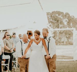 La joven caminando hacia el altar con su padre y su padrastro La joven caminando hacia el altar con su padre y su padrastro