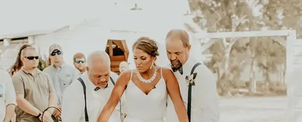 La joven caminando hacia el altar con su padre y su padrastro La joven caminando hacia el altar con su padre y su padrastro