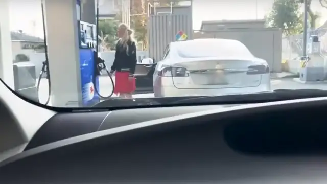 Una mujer se desespera al intentar poner gasolina a un coche eléctrico
