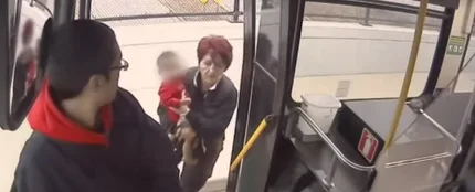 La conductora metiendo al pequeño en el autobús La conductora metiendo al pequeño en el autobús