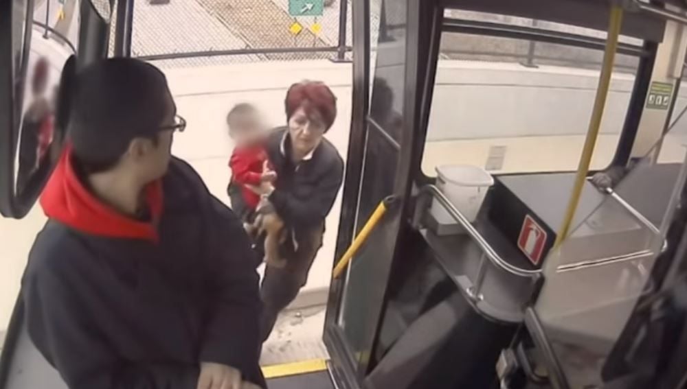 La conductora metiendo al pequeño en el autobús