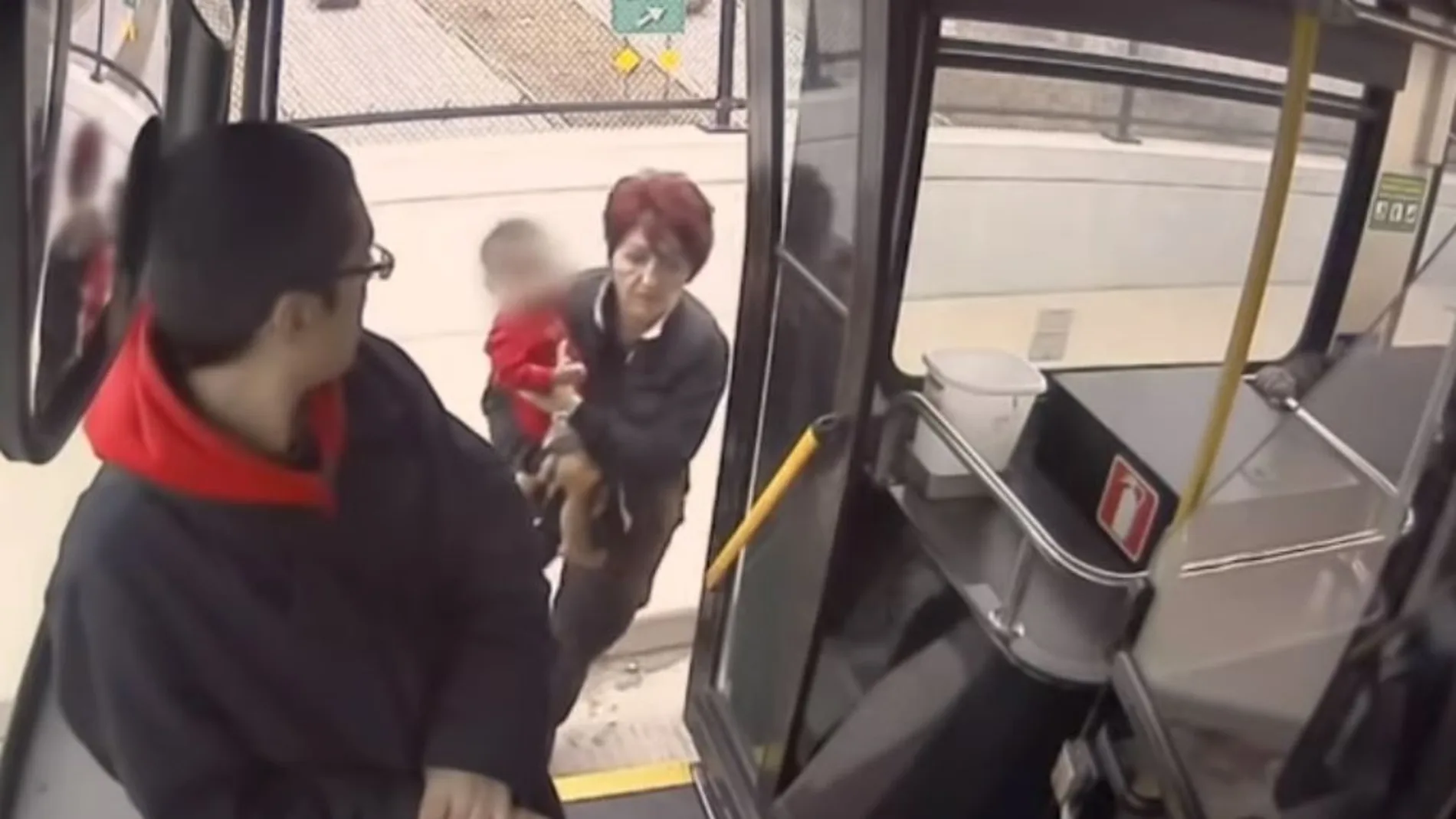 La conductora metiendo al pequeño en el autobús La conductora metiendo al pequeño en el autobús