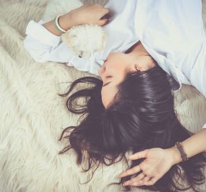 mujer durmiendo en una cama con un perro mujer durmiendo en una cama con un perro