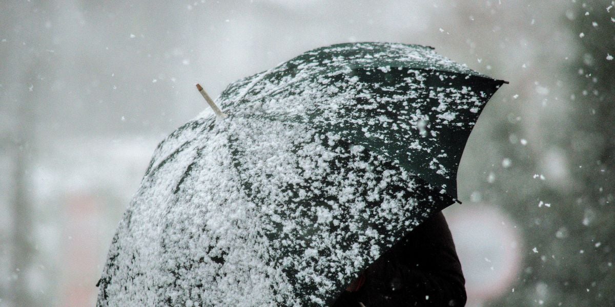 Una mujer camina por una calle nevada en A Gudiña