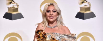 Lady Gaga sujetando sus tres premios Grammy