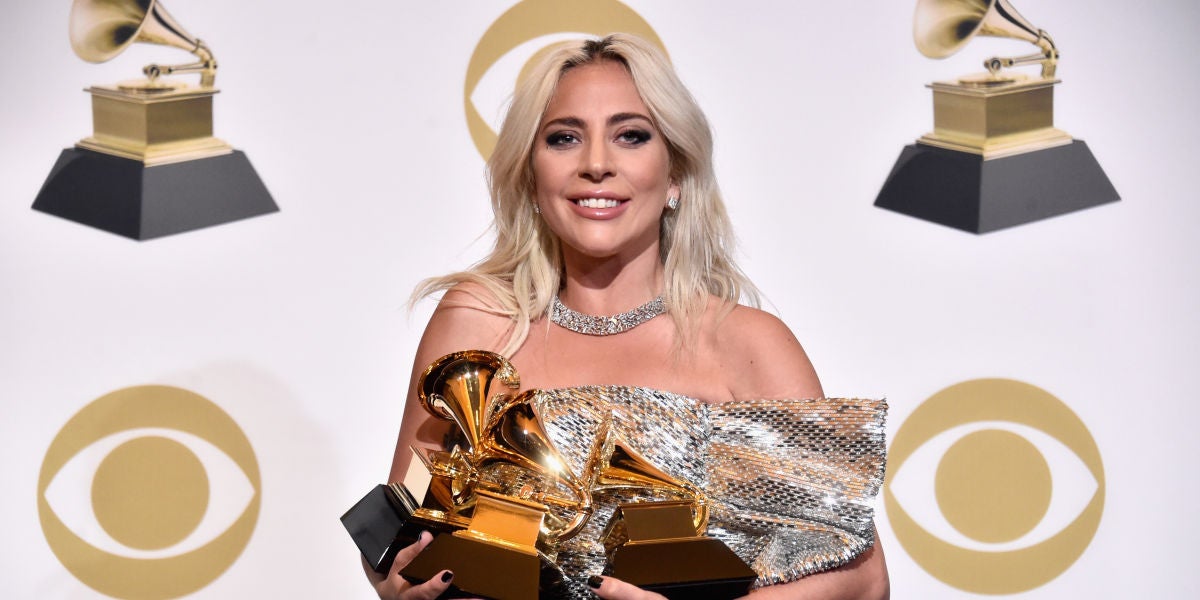 Lady Gaga sujetando sus tres premios Grammy