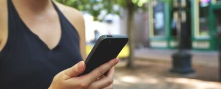 Una usuaria con su tel&eacute;fono m&oacute;vil