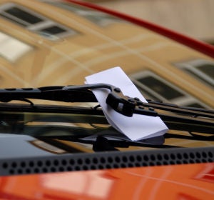 Una nota en el limpiaparabrisas de un coche Una nota en el limpiaparabrisas de un coche