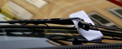 Una nota en el limpiaparabrisas de un coche Una nota en el limpiaparabrisas de un coche