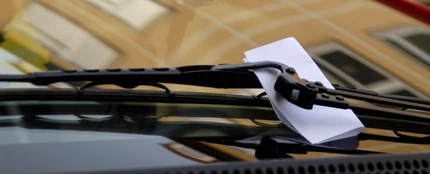 Una nota en el limpiaparabrisas de un coche Una nota en el limpiaparabrisas de un coche