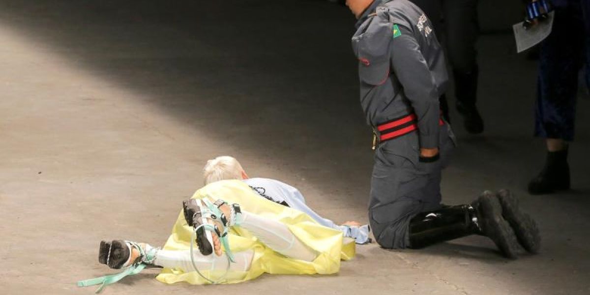 Un bombero auxilia al modelo Tales Cotta durante un desfile de la Semana de la Moda en Sao Paulo (Brasil)