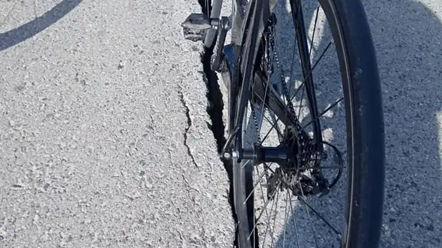 Carretera agrietada trancurrida por ciclista....