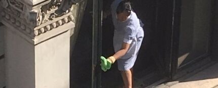 La limpiadora sacando brillo a la ventana