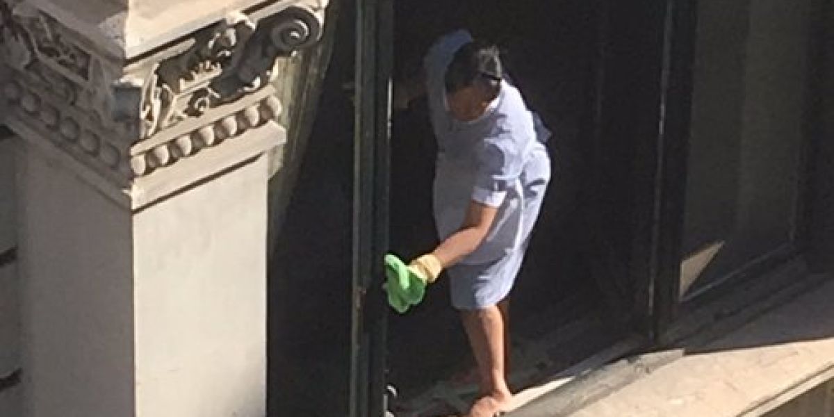 La limpiadora sacando brillo a la ventana