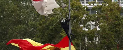 El paracaidista que descendía portando la bandera, en la farola en la que se enganchó El paracaidista que descendía portando la bandera, en la farola en la que se enganchó