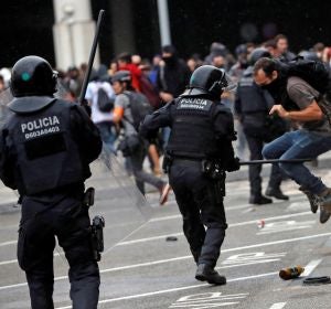 Miembros de los Mossos d'Esquadra cargan contra los centenares de personas que se agolpan ante el Aeropuerto del Prat Miembros de los Mossos d'Esquadra cargan contra los centenares de personas que se agolpan ante el Aeropuerto del Prat