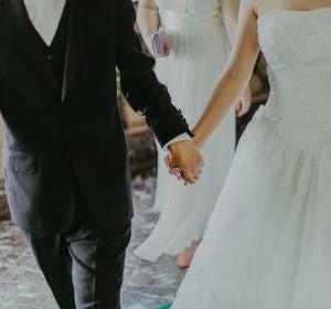 Unos novios cogidos de la mano en su boda Unos novios cogidos de la mano en su boda