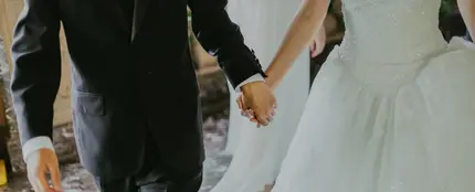 Unos novios cogidos de la mano en su boda Unos novios cogidos de la mano en su boda
