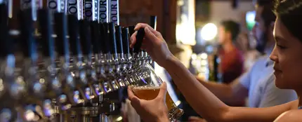 Una camarera sirviendo cerveza en un bar Una camarera sirviendo cerveza en un bar