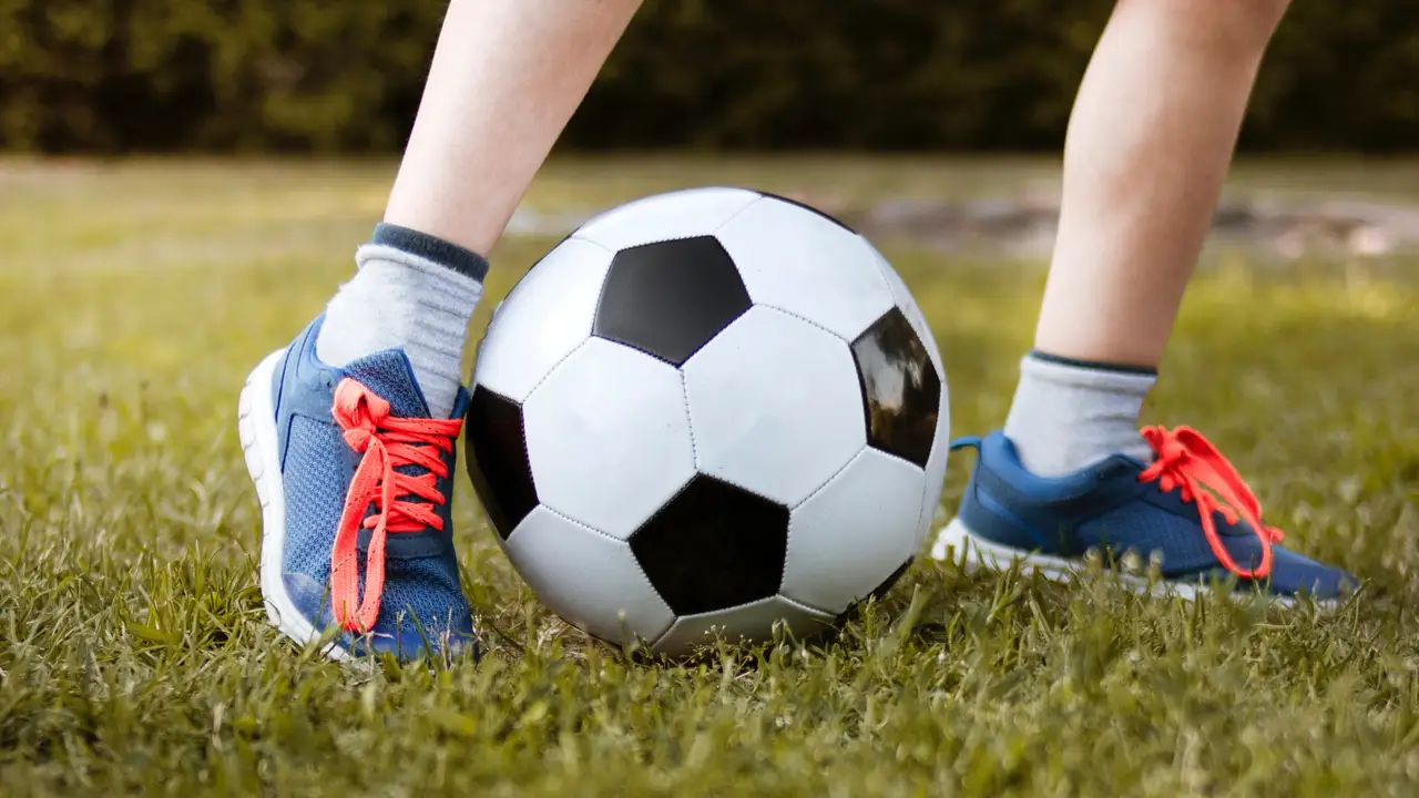 Un niño jugando al fútbol Un niño jugando al fútbol