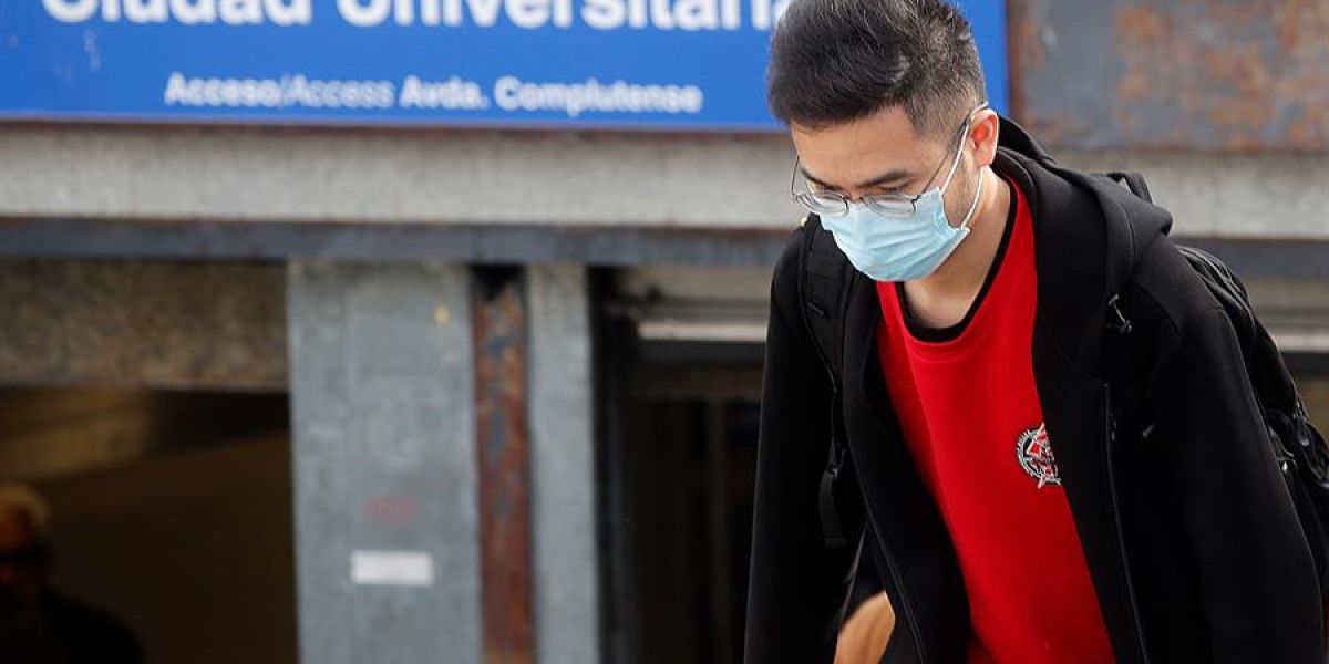 Un joven con mascarilla en el acceso a la estación de metro de Ciudad Universitaria, en Madrid