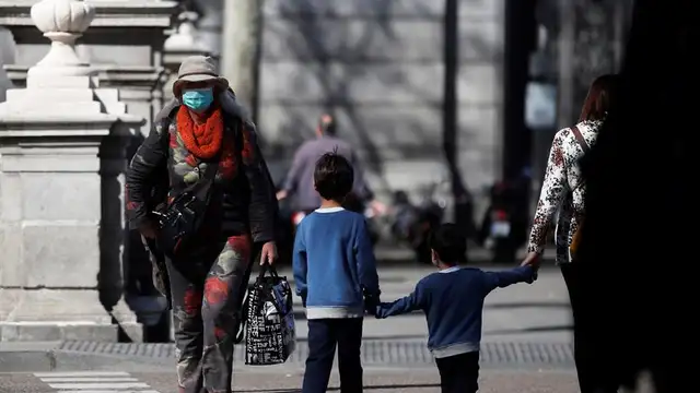 Un par de niños cruzan una calle en Madrid