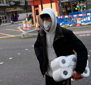 Un ciudadano británico, con rollos de papel higiénico en el brazo izquierdo Un ciudadano británico, con rollos de papel higiénico en el brazo izquierdo