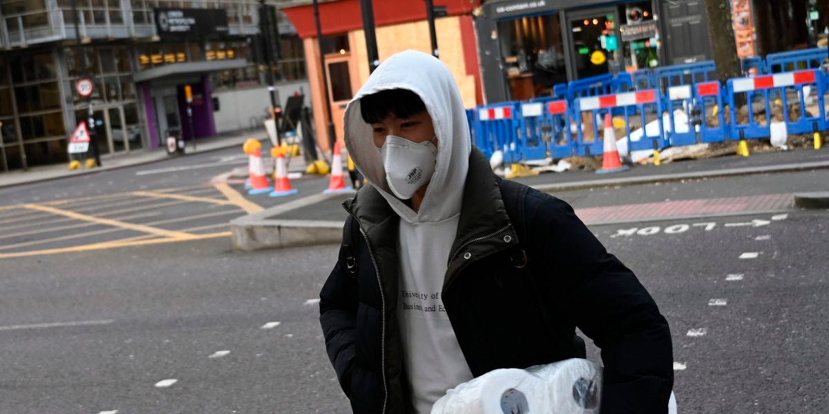 Un ciudadano británico, con rollos de papel higiénico en el brazo izquierdo
