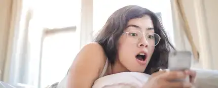 Una chica asombrada mirando el móvl Una chica asombrada mirando el móvl