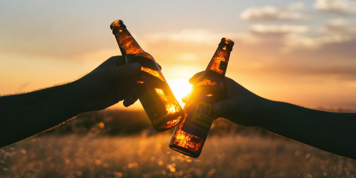 Brindis con cerveza en un campo de trigo