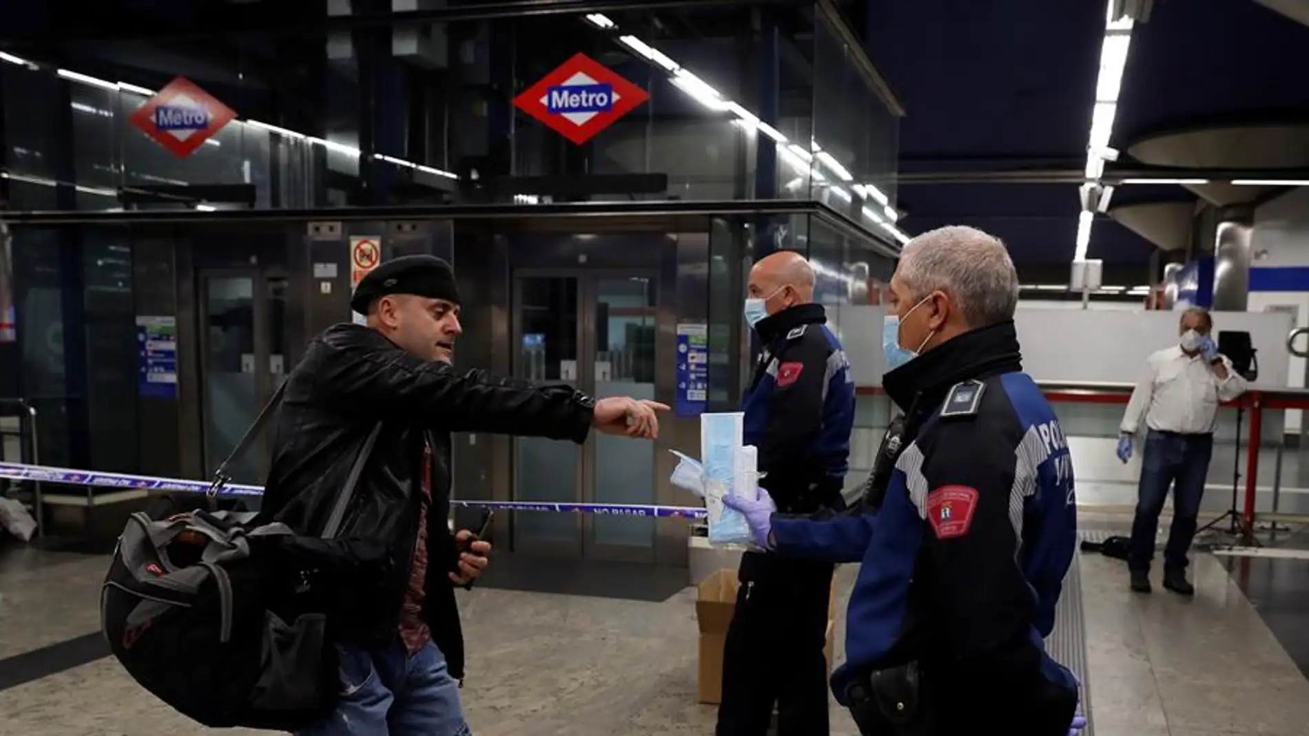 Policías entregan mascarillas en la estación de metro de Nuevos Ministerios en Madrid, este lunes.  title=