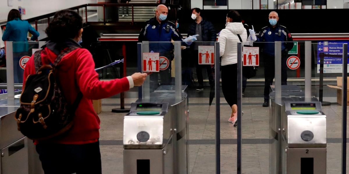 Policías entregan mascarillas en la estación de metro de Nuevos Ministerios en Madrid
