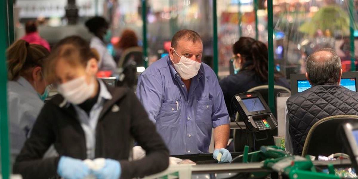 Varias personas hacen la compra en un supermercado de Madrid