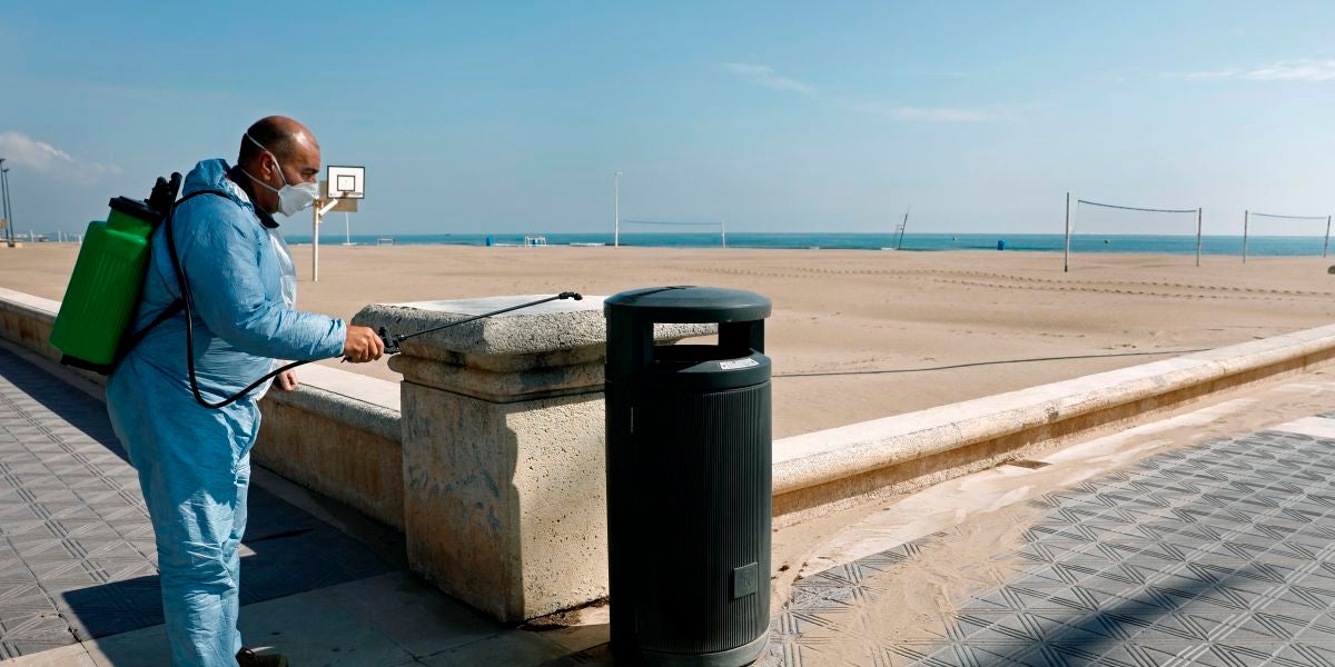 Un operario desinfecta una papelera ante una playa de la Malvarrosa (Valencia)