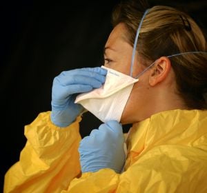 Una enfermera poniéndose la mascarilla Una enfermera poniéndose la mascarilla