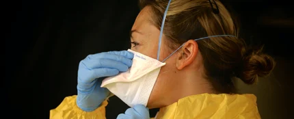 Imagen de archivo de una enfermera poniéndose la mascarilla Imagen de archivo de una enfermera poniéndose la mascarilla