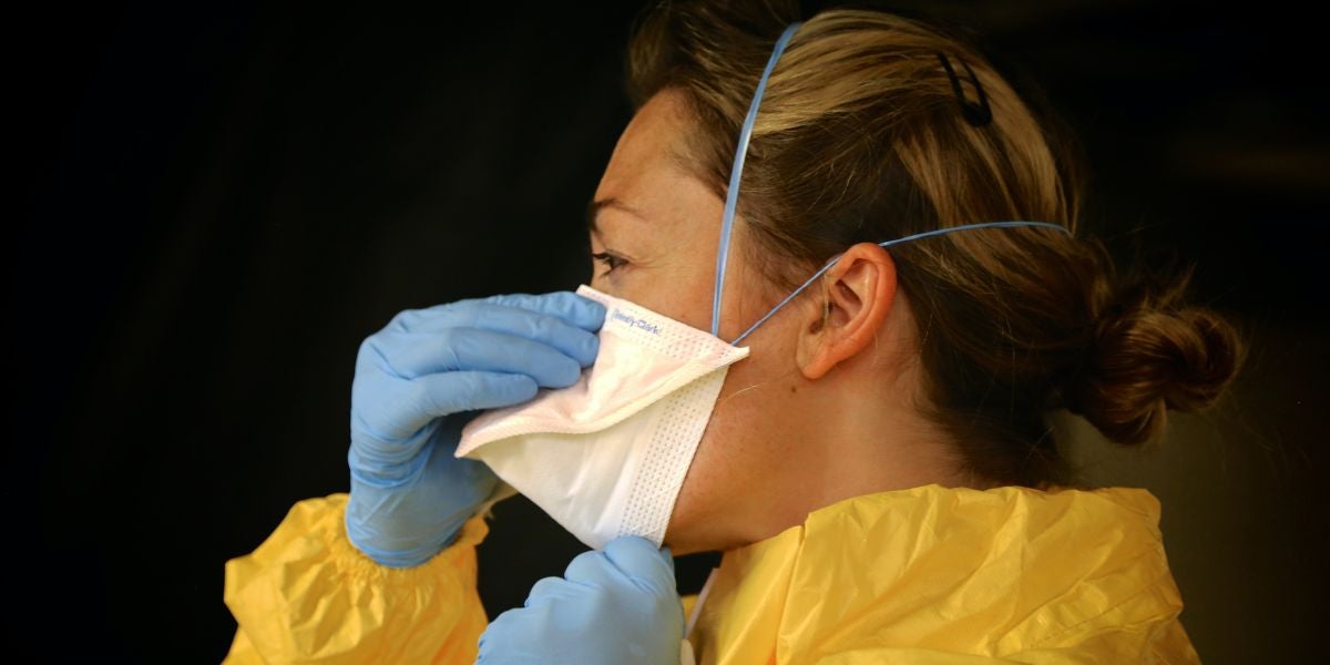 Una enfermera poniéndose la mascarilla