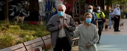 Una pareja protegida con mascarillas pasea por la Rambla Nova de Sants Una pareja protegida con mascarillas pasea por la Rambla Nova de Sants