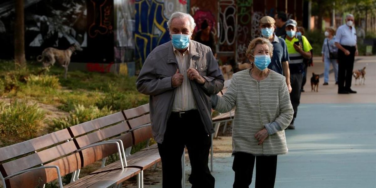 Una pareja protegida con mascarillas pasea por la Rambla Nova de Sants