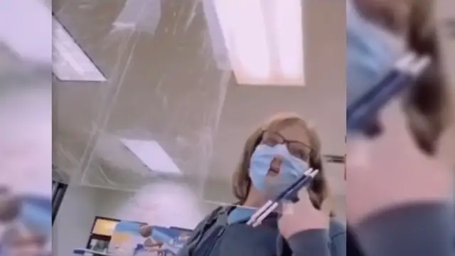 Una mujer lleva la mascarilla con un agujero en la nariz y la boca