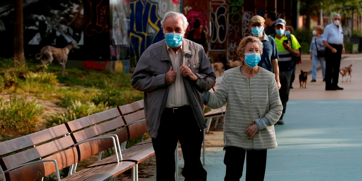 Dos personas mayores paseando con mascarilla