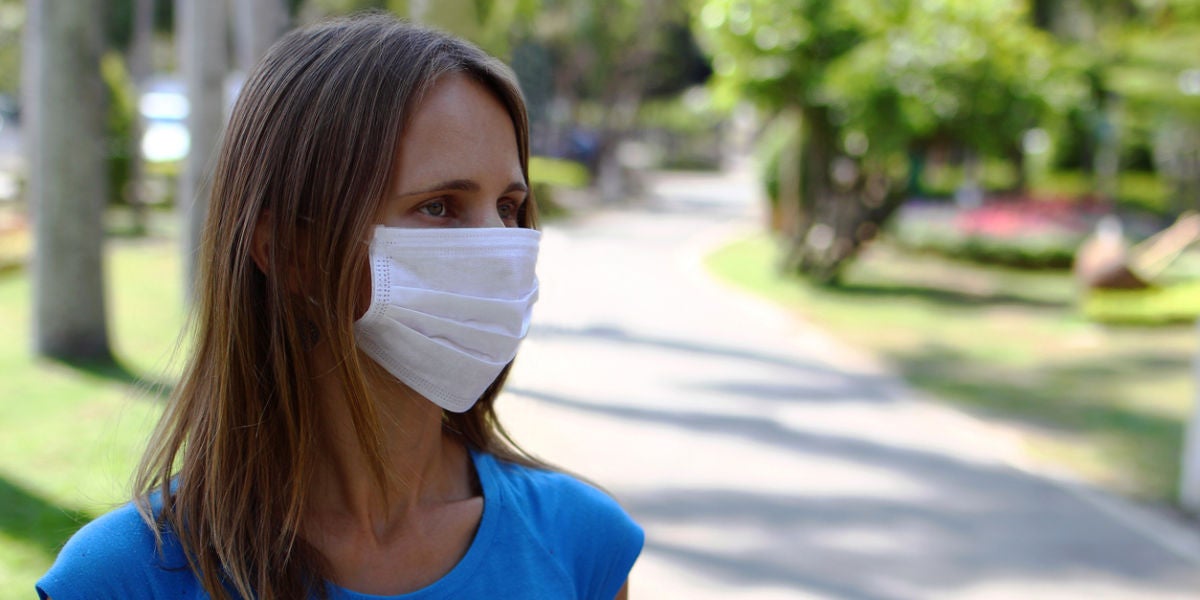 Una mujer en la calle con mascarilla