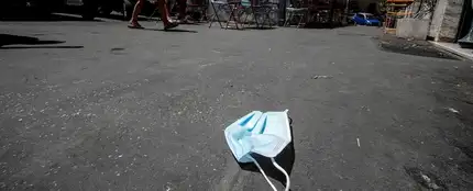 Imagen de una mascarilla de protección tirada en el suelo en una calle de Roma Imagen de una mascarilla de protección tirada en el suelo en una calle de Roma