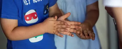 Dos niños de desinfectan las manos con gel hidroalcohólico Dos niños de desinfectan las manos con gel hidroalcohólico
