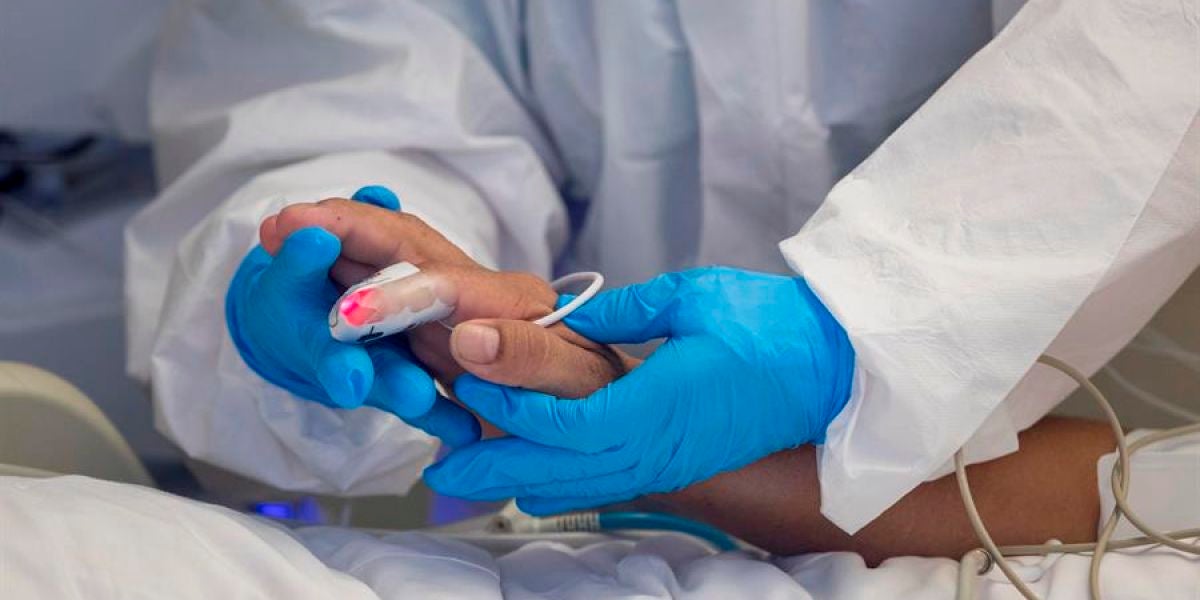 Un sanitario atiende a un paciente hospitalizado por coronavirus.
